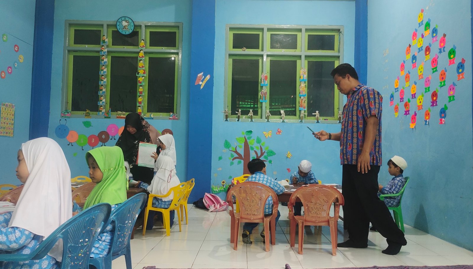 Salah satu Tim Penilai Akreditas mendokumentasikan aktivitas anak siswa TK ABA 1 Wagom dalam menyelesaikan tugas yang diberikan pengajar