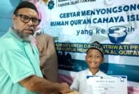 Ketua Yayasan Cahaya Islam Fakfak menyerahkan hadiah lomba dalam rangka Milad ke-3, Rumah Qur'an Cahaya Islam Fakfak